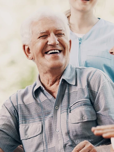 A groups of seniors laughing while sitting in a park