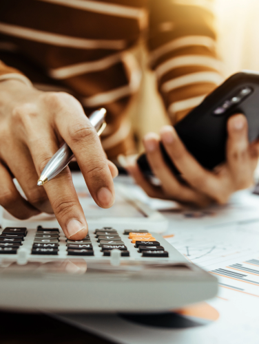images of a person balancing a budget with a calculator.